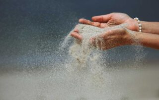 Sand Flowing Through Fingers